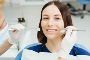 Dental professional inspecting a patient’s oral health