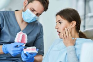 Dentist showing a denture to a patient during a dental consultation