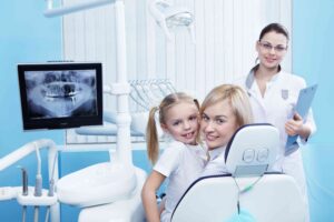 Mother and child smiling during a family dental visit.