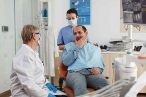 Patient discussing tooth pain with a dentist.
